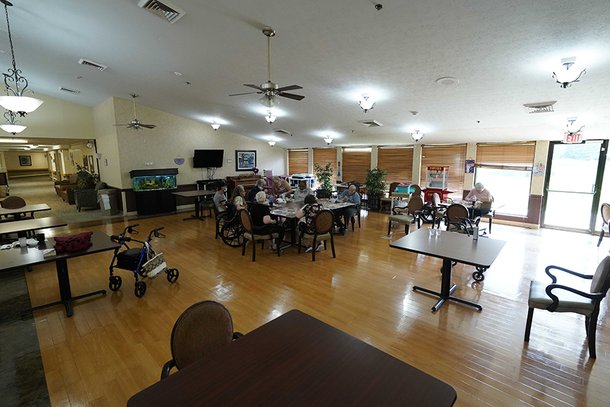 Dining table with people gathering in resident lounge- Arbors at Streetsboro